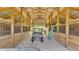 Interior view of the barn showcasing open stalls and ample storage space for equipment and vehicles at 1385 Ewell Rd, Lakeland, FL 33811