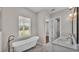 Bright bathroom featuring a soaking tub, marble floors, and double vanity sinks at 1385 Ewell Rd, Lakeland, FL 33811