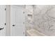 Bathroom showcasing marble-patterned tile shower and a white door at 1385 Ewell Rd, Lakeland, FL 33811