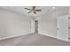 This bedroom features neutral carpeting, a ceiling fan, and two white doors at 1385 Ewell Rd, Lakeland, FL 33811