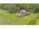 Aerial view of chicken coop showcasing a secure outdoor run and adjacent storage shed on green lawn at 1385 Ewell Rd, Lakeland, FL 33811