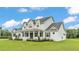 Charming two-story farmhouse with a welcoming porch and lush landscaping on a sunny day at 1385 Ewell Rd, Lakeland, FL 33811