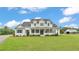 Beautiful two-story home with a classic white exterior, large front porch, and well-manicured lawn at 1385 Ewell Rd, Lakeland, FL 33811