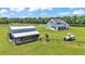 Sprawling property featuring a charming farmhouse, large barn, and boat on lush green acreage at 1385 Ewell Rd, Lakeland, FL 33811