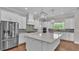 Modern kitchen boasts stainless appliances, a large island, white cabinets, and designer pendant lights at 1385 Ewell Rd, Lakeland, FL 33811