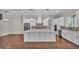 A spacious kitchen featuring white cabinets, stainless steel appliances, a large island, and hardwood floors at 1385 Ewell Rd, Lakeland, FL 33811