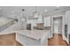 Open kitchen design featuring a large island, white cabinetry, stainless appliances, and hardwood floors at 1385 Ewell Rd, Lakeland, FL 33811