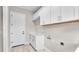 Clean laundry room featuring white cabinets, marbled floors, and a convenient door at 1385 Ewell Rd, Lakeland, FL 33811