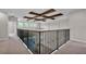 Spacious loft area with coffered ceilings, a ceiling fan, and a modern iron railing at 1385 Ewell Rd, Lakeland, FL 33811