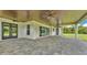 Long covered patio featuring stone pavers, a wood ceiling, and multiple ceiling fans at 1385 Ewell Rd, Lakeland, FL 33811