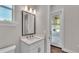 Well-lit powder room with stone countertops, a mirror, and a view of the outdoor patio at 1385 Ewell Rd, Lakeland, FL 33811