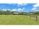 Exterior view of a horse barn and fenced pasture, surrounded by mature trees at 1385 Ewell Rd, Lakeland, FL 33811