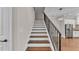 Elegant staircase with dark wood steps, white risers, and an iron railing at 1385 Ewell Rd, Lakeland, FL 33811