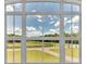 Bright view of open field and trees through divided light windows at 1385 Ewell Rd, Lakeland, FL 33811