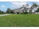 Spacious front yard featuring lush green grass, mature trees and shrubs, and a whitewashed brick house at 1425 Hallam Dr, Lakeland, FL 33813