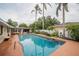 A refreshing pool surrounded by lush landscaping and tall palm trees at 1425 Hallam Dr, Lakeland, FL 33813