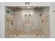 Luxurious shower features marble-style tiles, dual shower heads, and a frameless glass enclosure at 1531 Blue Sky Blvd, Haines City, FL 33844