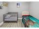 Bedroom featuring gray walls, a crib and a bed with dinosaur sheets at 1531 Blue Sky Blvd, Haines City, FL 33844