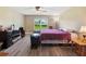 A relaxing bedroom with a ceiling fan, window overlooking the yard, and wood-look flooring at 1531 Blue Sky Blvd, Haines City, FL 33844