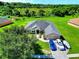 A meticulously landscaped property shows a well-maintained lawn, mature trees, and a three-car paved driveway at 1531 Blue Sky Blvd, Haines City, FL 33844