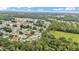 Expansive aerial view of a neighborhood with lush greenery and scattered residences under a partly cloudy sky at 1746 Grey Fox Dr, Lakeland, FL 33810