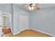 Bedroom featuring wood-look floors, light blue walls, double closet, and view into connecting room at 1746 Grey Fox Dr, Lakeland, FL 33810