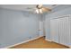 Bedroom featuring wood-look floors, light blue walls, double closet, and ceiling fan at 1746 Grey Fox Dr, Lakeland, FL 33810
