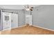 Bedroom with wood-look floors, neutral walls, ceiling fan, sliding barn door to bathroom and closet at 1746 Grey Fox Dr, Lakeland, FL 33810