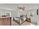 Bright bedroom with a traditional wrought iron bed, ceiling fan, and two windows at 1910 Clubhouse Rd, Lakeland, FL 33813