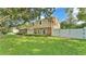 Lovely two-story home showcasing a well-manicured lawn and secure white fence, blending privacy and curb appeal at 1910 Clubhouse Rd, Lakeland, FL 33813