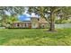 Charming two-story brick home with blue shutters and lush front yard shaded by mature trees at 1910 Clubhouse Rd, Lakeland, FL 33813