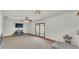 Spacious carpeted living room with a ceiling fan, TV, and glass doors leading to the outside at 1910 Clubhouse Rd, Lakeland, FL 33813