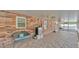 Extended covered patio with a brick wall, ceiling fans, and a comfortable bench for relaxation at 1910 Clubhouse Rd, Lakeland, FL 33813
