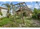 Backyard featuring pergola, lush foliage, tropical plants, and partially fenced perimeter at 1927 E Main St, Lakeland, FL 33801