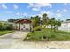 Home with one car garage and tropical landscaped front yard with palm trees at 1927 E Main St, Lakeland, FL 33801