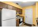 Traditional kitchen with white refrigerator and oven, wood cabinets and yellow walls at 1927 E Main St, Lakeland, FL 33801