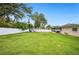 Generous backyard with healthy green grass, a play set, and a screened lanai at 2110 Bristol Ave, Lakeland, FL 33803