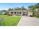 Well-maintained single-story home with a covered parking area and a beautifully landscaped front yard and concrete driveway at 2110 Bristol Ave, Lakeland, FL 33803