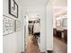 Hallway leading to walk-in closet and bathroom, showcasing modern design with decorative touches and dark wood flooring at 2110 Bristol Ave, Lakeland, FL 33803