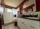 Red and grey striped bathroom with white tile shower, toilet, and vanity at 2424 Bates Sw Ave, Winter Haven, FL 33880