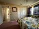 Bedroom with double closet, queen bed and floral bedding, next to hallway at 2424 Bates Sw Ave, Winter Haven, FL 33880