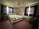 Bedroom with floral bedding, ceiling fan, and two large windows at 2424 Bates Sw Ave, Winter Haven, FL 33880