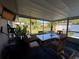 Enclosed porch with dining table, exercise bike and views of the fenced backyard at 2424 Bates Sw Ave, Winter Haven, FL 33880