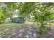 Large backyard with shady trees, green grass, and fenced in yard at 2711 Crutchfield Rd, Lakeland, FL 33805
