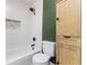Modern bathroom featuring a new toilet, a bathtub with white tile, and stylish storage cabinet at 2711 Crutchfield Rd, Lakeland, FL 33805