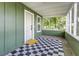 Cozy front porch featuring a checkered rug, white door, and screened windows, a perfect spot for relaxation at 2711 Crutchfield Rd, Lakeland, FL 33805