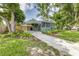 Charming home with lush landscaping, a carport, and a cozy screened-in porch offering great curb appeal at 2711 Crutchfield Rd, Lakeland, FL 33805