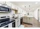 Bright kitchen with white cabinets, granite countertops, stainless steel appliances, and modern pendant lighting at 2711 Crutchfield Rd, Lakeland, FL 33805