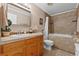 Bathroom with a shower-tub combo, tiled walls, a beige vanity, and neutral walls at 2911 Walker Rd, Lakeland, FL 33810