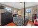 Bedroom featuring wood floors, two windows, and a four poster bed at 2911 Walker Rd, Lakeland, FL 33810